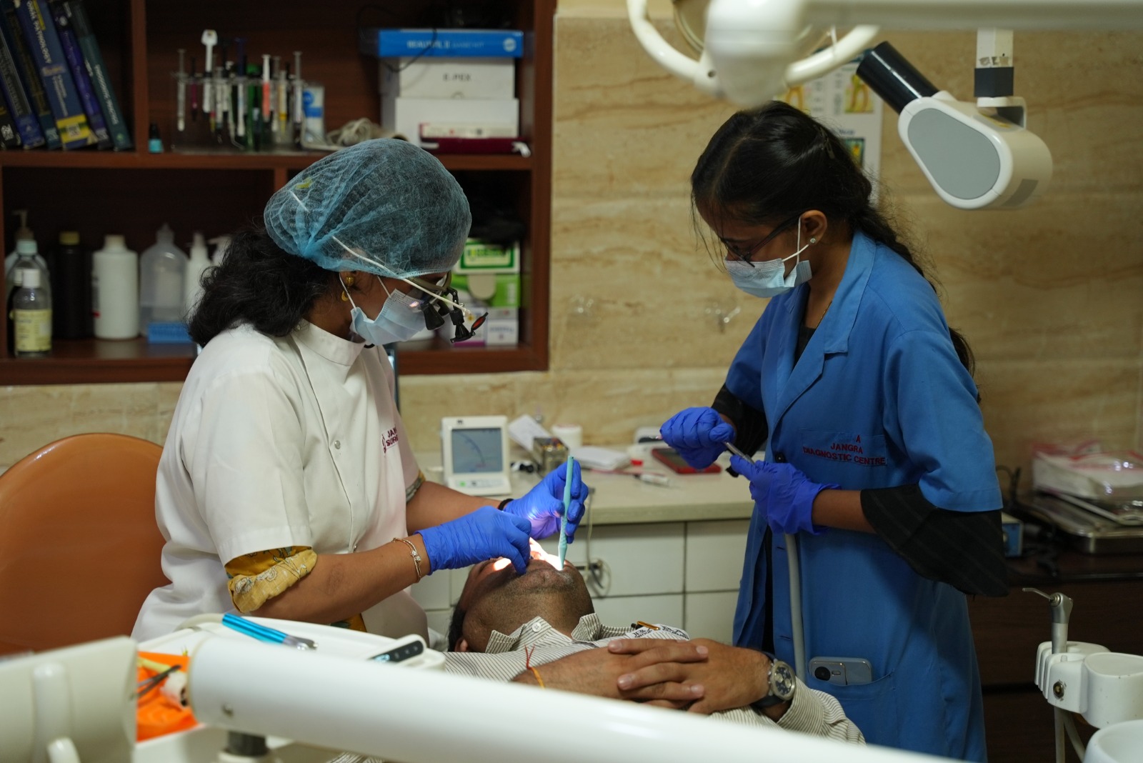 Dr. Neha Jangra and dental assistant treating a patient in the dental operatory